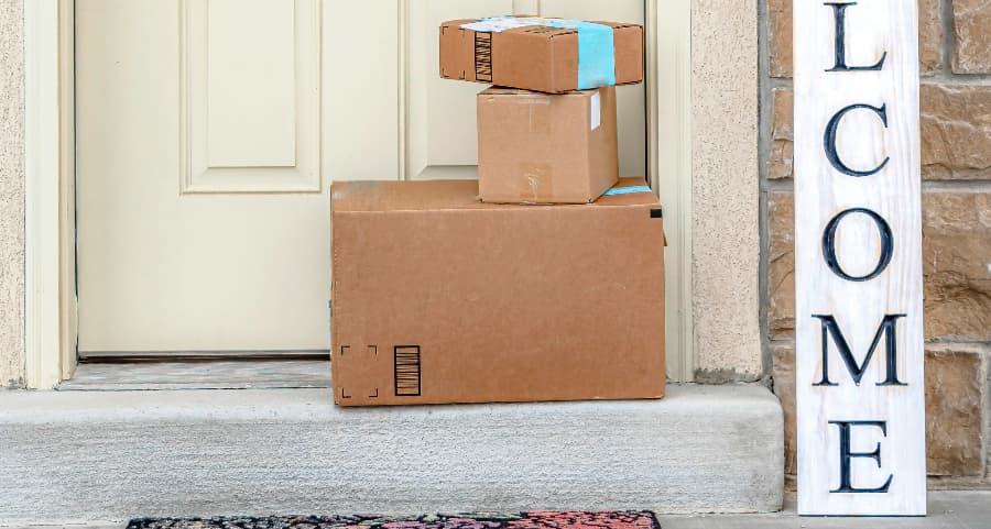 Packages on the doorstep of a home with a welcome sign in Manchester